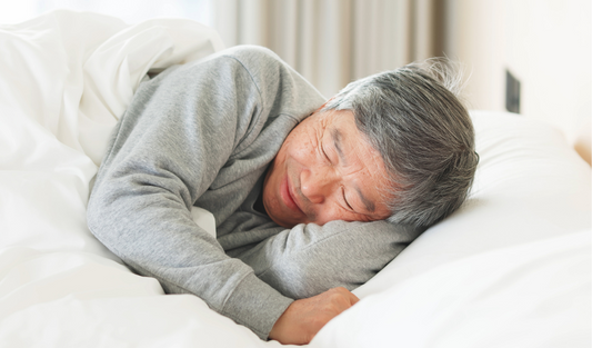 Older adult sleeping peacefully on their side after improving nocturia and reducing nighttime bathroom trips naturally.